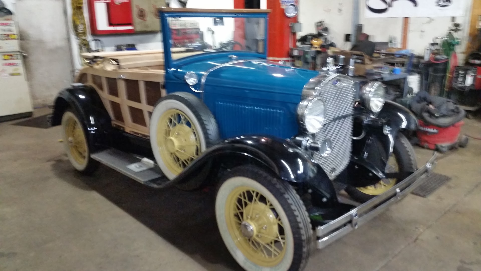 A blue Ford Model A roadster pickup in the shop